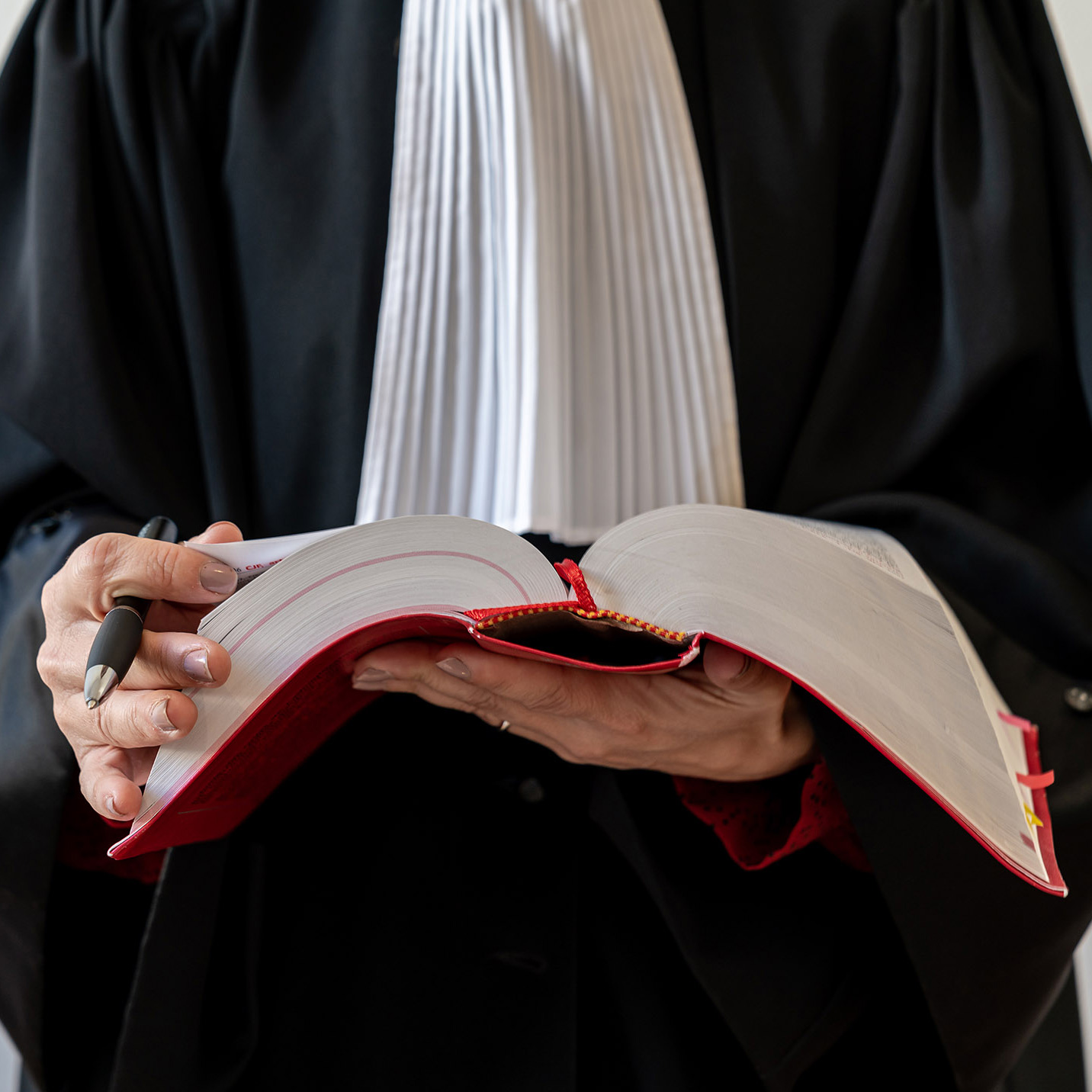Avocat en robe, tenant un livre de droit