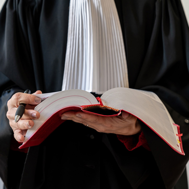 Avocat en robe, tenant un livre de droit
